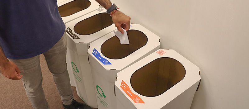 Person recycling using cardboard bins